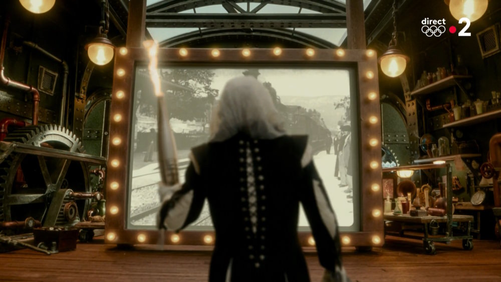 The mystery figure watches a historic film clip